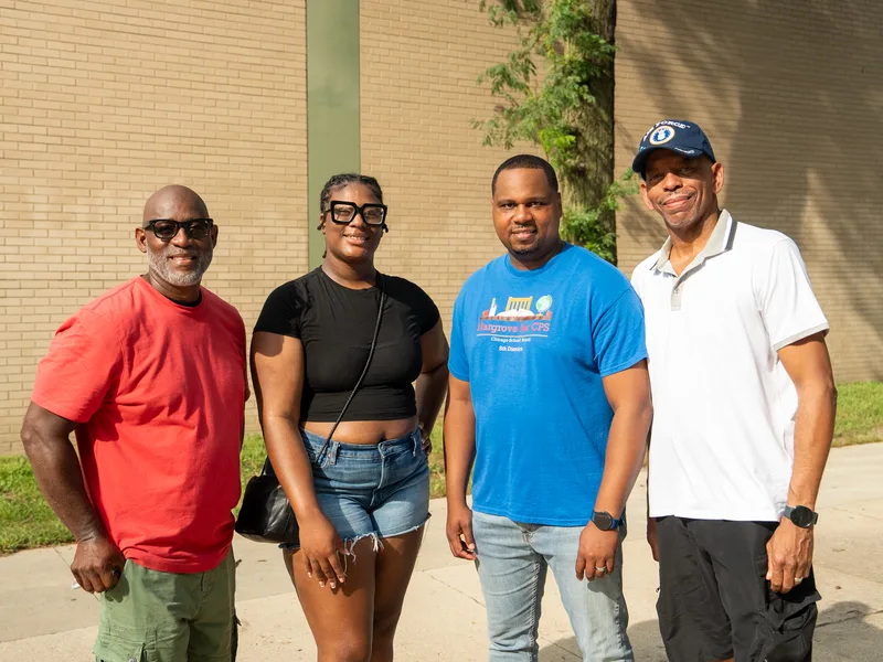Anthony Hargrove in a blue shirt standing with three adults outdoors.