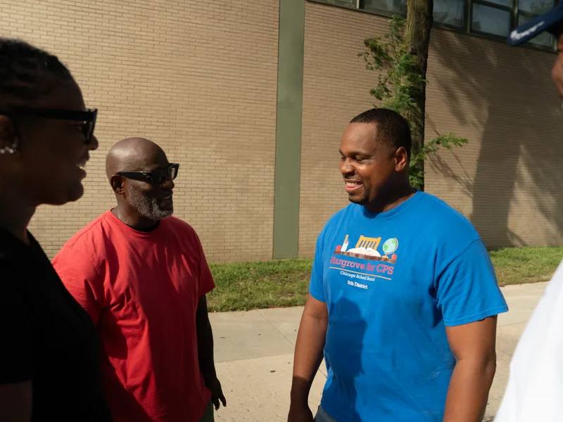 Anthony Hargrove smiling during a conversation with a small group outdoors.