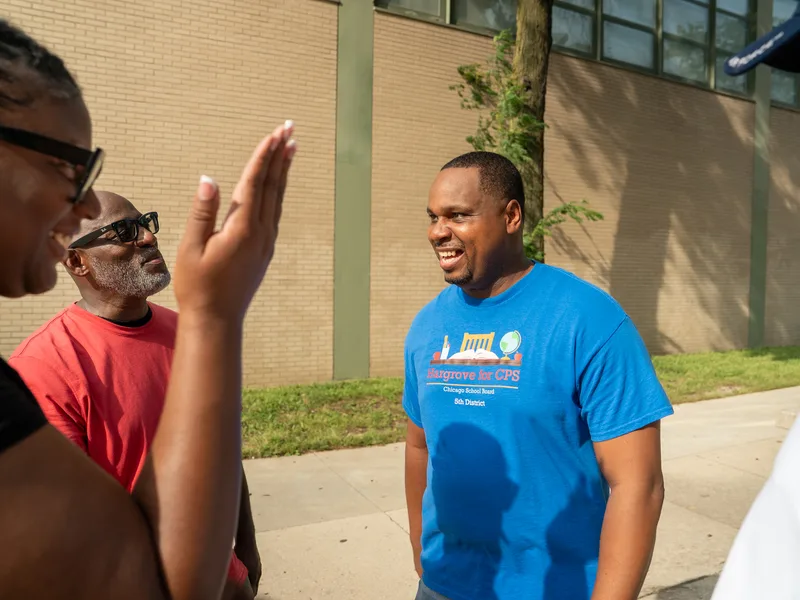 Anthony Hargrove listening as a woman gestures during an outdoor conversation.