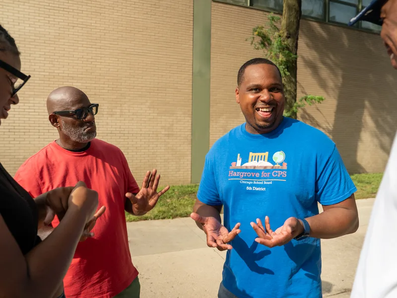 Anthony Hargrove and a man in a red shirt gesturing during a conversation.