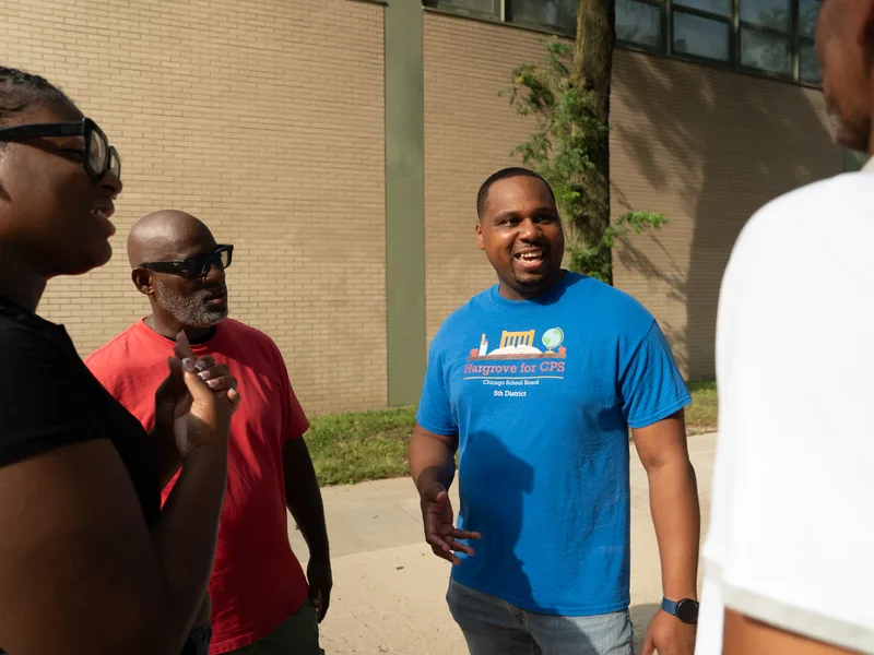 Anthony Hargrove standing with a small group during an outdoor conversation.