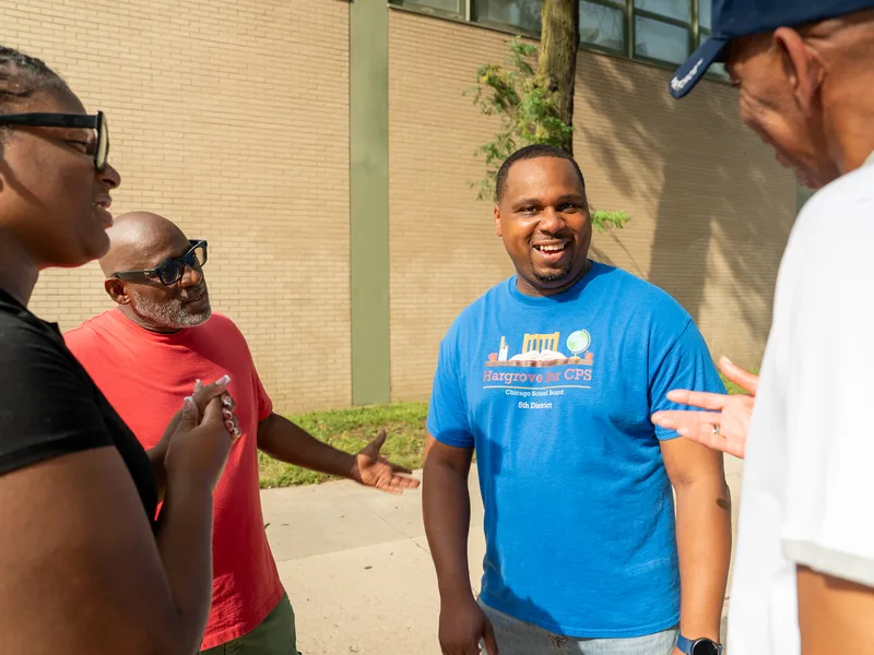 Anthony Hargrove smiling while talking with a group of adults outdoors.