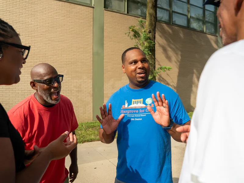 Anthony Hargrove gesturing beside a laughing man in a red shirt.