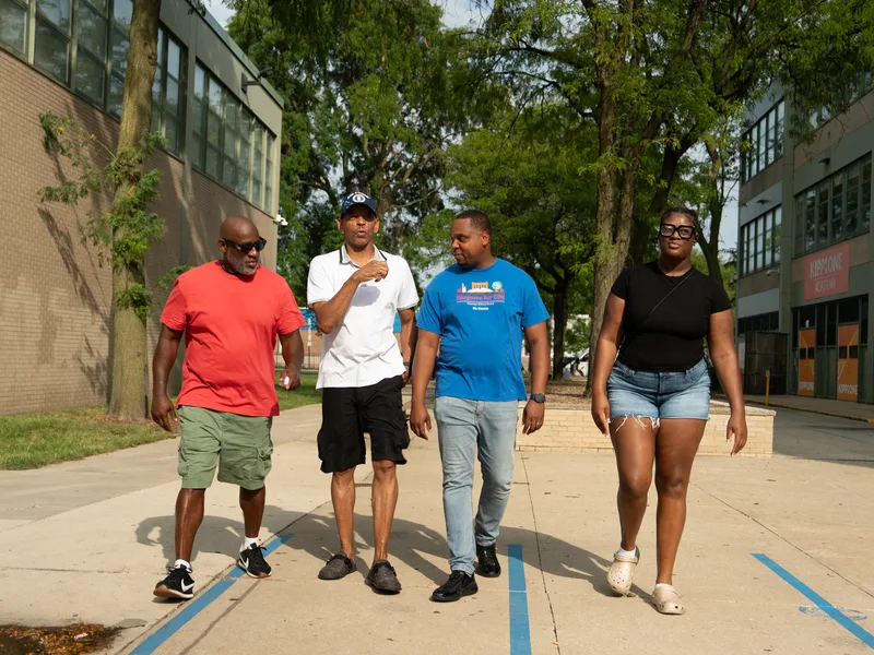 Anthony Hargrove walking with a small group beside a school.