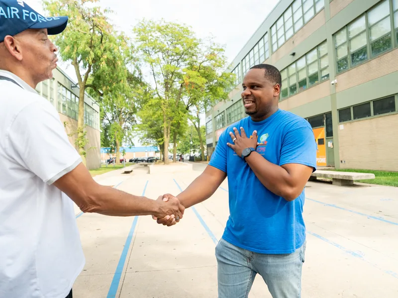 Anthony Hargrove shaking hands with a man wearing a white cap.