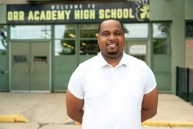 Anthony Hargrove in a white polo shirt standing outside a school.