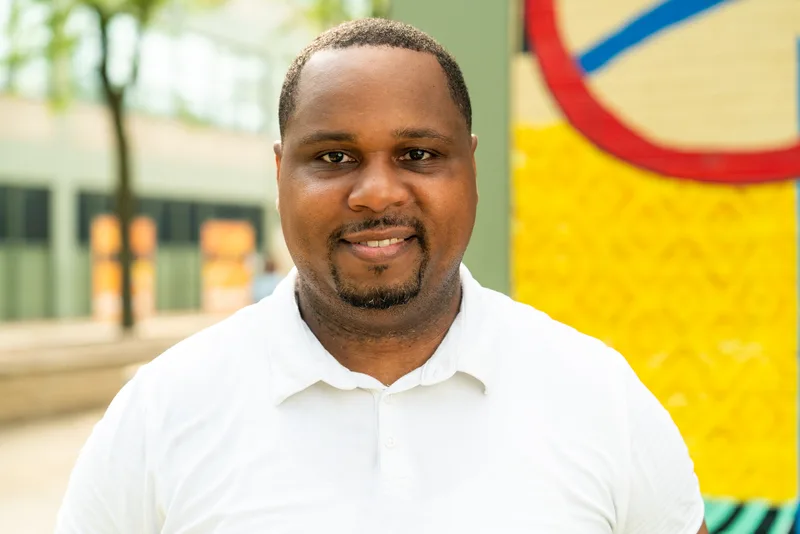 Anthony Hargrove smiling in front of a colorful mural.