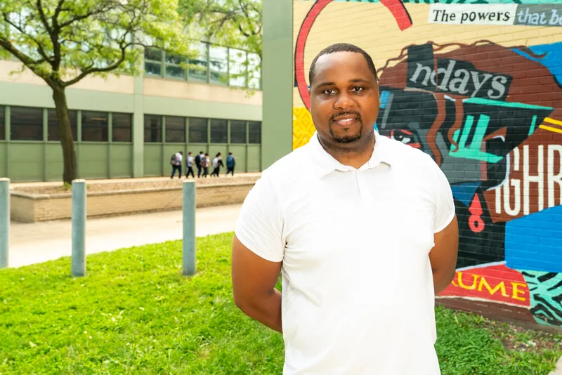 Anthony Hargrove in a white polo shirt standing beside a colorful mural.