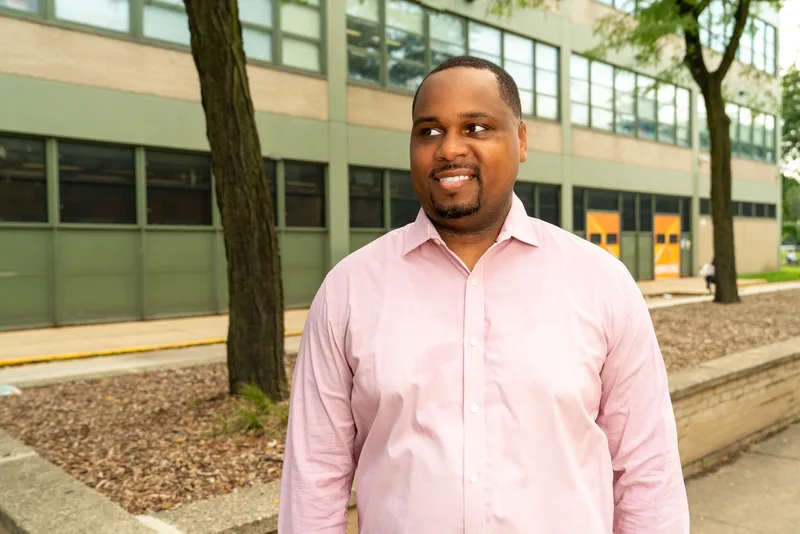 Anthony Hargrove in a pink shirt looking to the side outdoors.