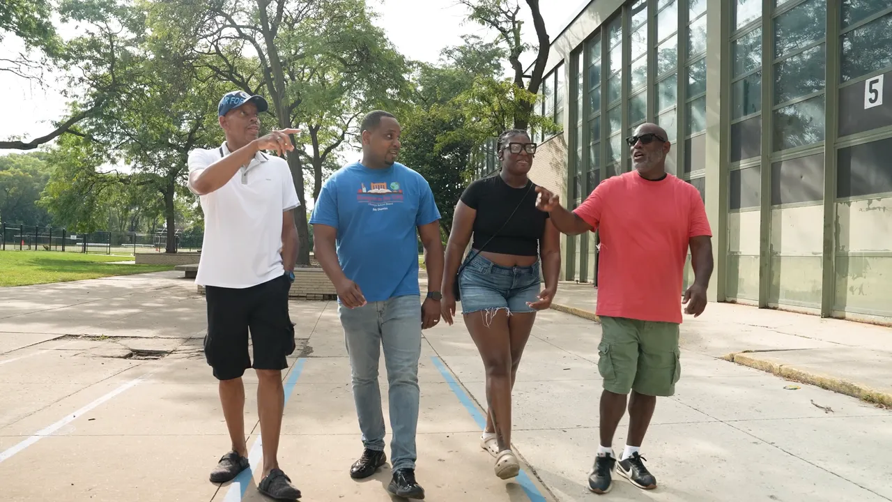Anthony Hargrove walking with three adults beside a school.